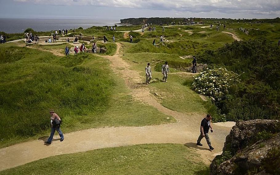 Visitors walk among the bomb craters at Pointe du Hoc, France, Saturday, June 7, 2014, where the U.S. Army Ranger Regiment scaled the cliffs on D-Day.
