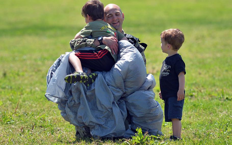 Callum Roberts watches his brother, Cade, hug their dad, Lt. Cmdr. Jake Roberts, after he parachuted into La Fi??re drop zone near Cauquigny, France, Sunday, June 8, 2014, in a 70th anniversary of D-Day commemoration.