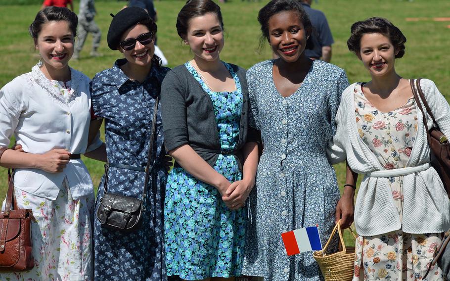 French women decked out in World War II-era clothing pose for photographers following a 70th anniversary of D-Day parachute drop near Cauquigny, France, Sunday, June 8, 2014.