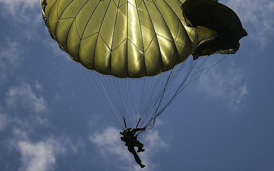A paratroop untangles a canopy as he jumps in Cauquigny, France, to commemorate the 70th anniversary of D-Day, Sunday, June 8, 2014.
                