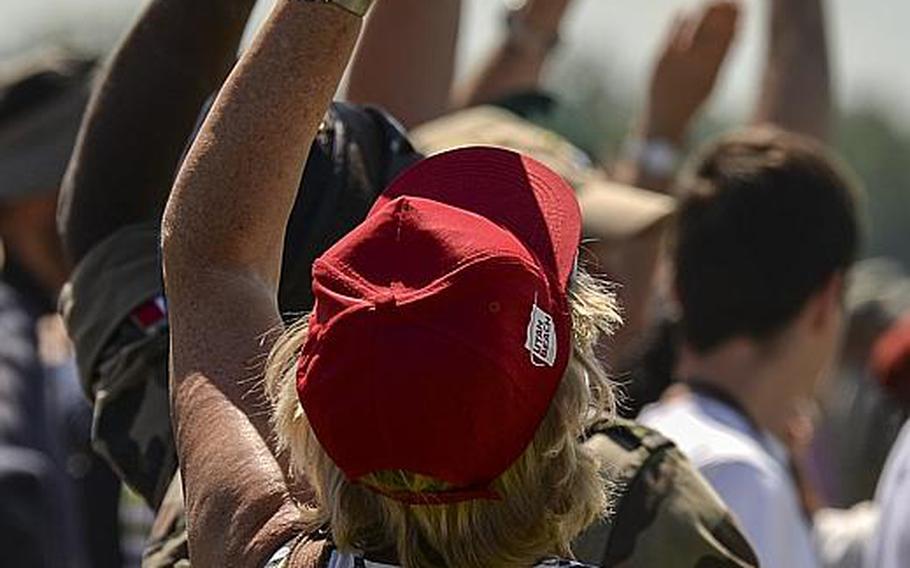 Spectators gaze upward as paratroops in Cauquigny, France, float to the ground during a parachute drop commemorating the 70th anniversary of D-Day, Sunday, June 8, 2014.
                