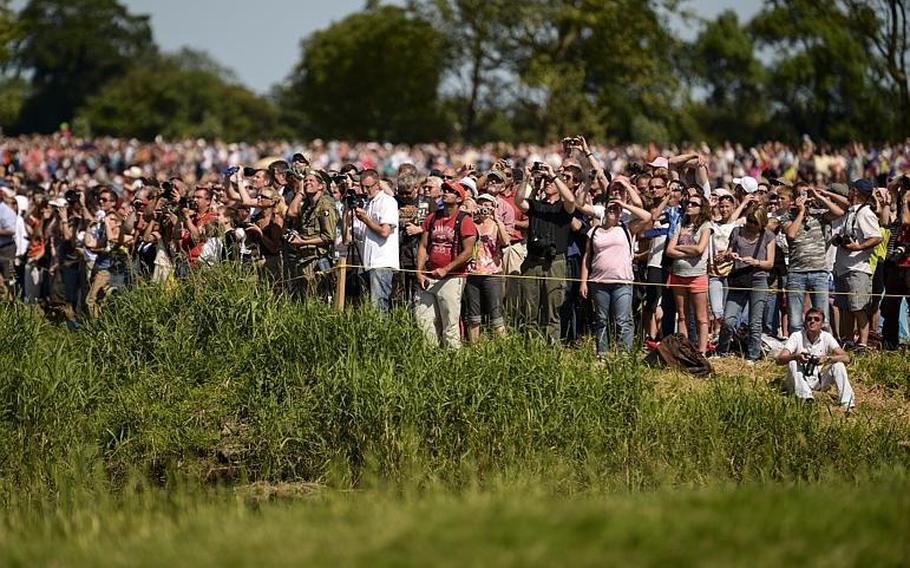 Spectators in Cauquigny, France, watch a parachute drop commemorating the 70th anniversary of D-Day, Sunday, June 8, 2014.
                