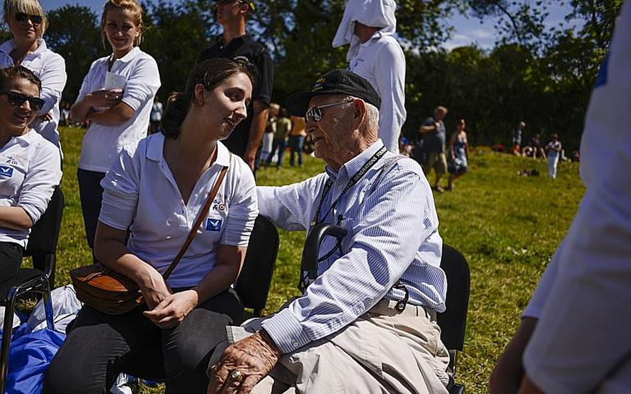 D-Day veteran Conrad Lohoefer, a former flight engineer with the 8th Air Force, 91st Bomb Group, 401st Bomb Squadron, visits with a volunteer nurse in Cauquigny, France, after watching a parachute drop commemorating the 70th anniversary of D-Day, Sunday, June 8, 2014.
                