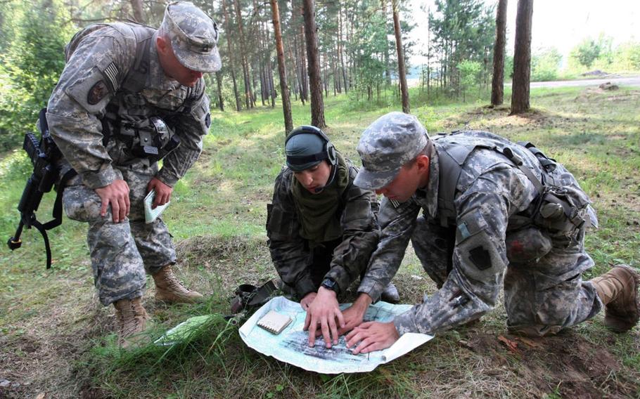 A Lithuanian Soldier and his U.S. counterparts study a map while making plans for a combined operation during exercise Saber Strike 2014.