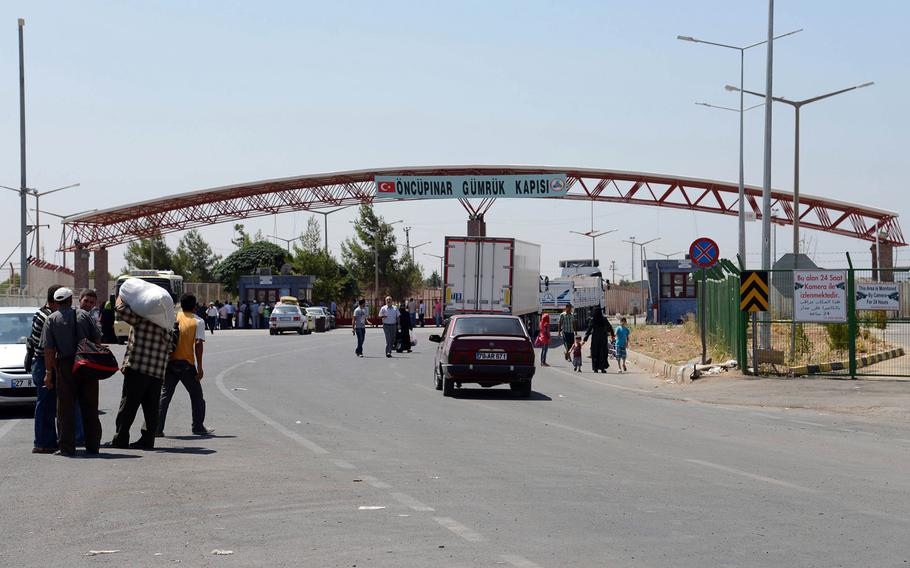 Pedestrians and vehicles travel between Syria and Turkey at the border crossing at Kilis, Turkey, in August 2013. Since the start of the civil war in Syria in 2011, scores of young men from Europe and the United States have slipped into Syria through Turkey.