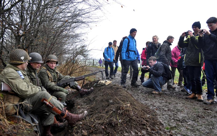 Participants in an annual walk to commemorate World War II's Battle of the Bulge stop to take photos of reenactors in period uniforms, Dec. 14, 2013.