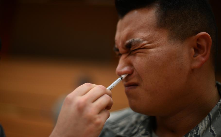 Air Force Staff Sgt. Dan Jackson receives a flu mist vaccine inside the Skelton Memorial Fitness Center at Spangdahlem Air Base, Germany, Oct. 23, 2014.
