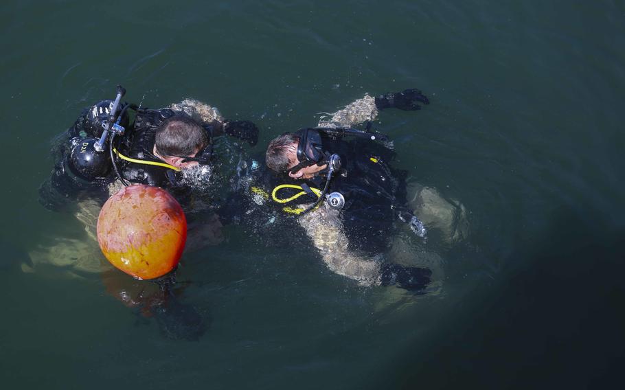 U.S. Marines with the Force Reconnaissance detachment, 11th Marine Expeditionary Unit, conduct buddy checks as a part of pier-search dive training Jan. 3, 2014. The 11th MEU is deployed with Makin Island Amphibious Ready Group as a theater reserve and crisis response force throughout U.S. Central Command and 5th Fleet area of responsibility.