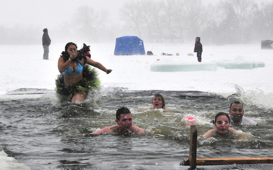 Staff Sgt. Andrea Rasmussen, 90th Civil Engineer Squadron explosive ordnance technician, jumps into the icy waters of Sloans Lake, Cheyenne, Wyo., as her team swims out Jan. 3, 2014. Rasmussen and her team participated in the third annual Schwartz Memorial Plunge in honor of Tech. Sgt. Matthew Schwartz, a 90th CES explosive ordnance technician who was killed in action while deployed to Afghanistan Jan. 5, 2012.