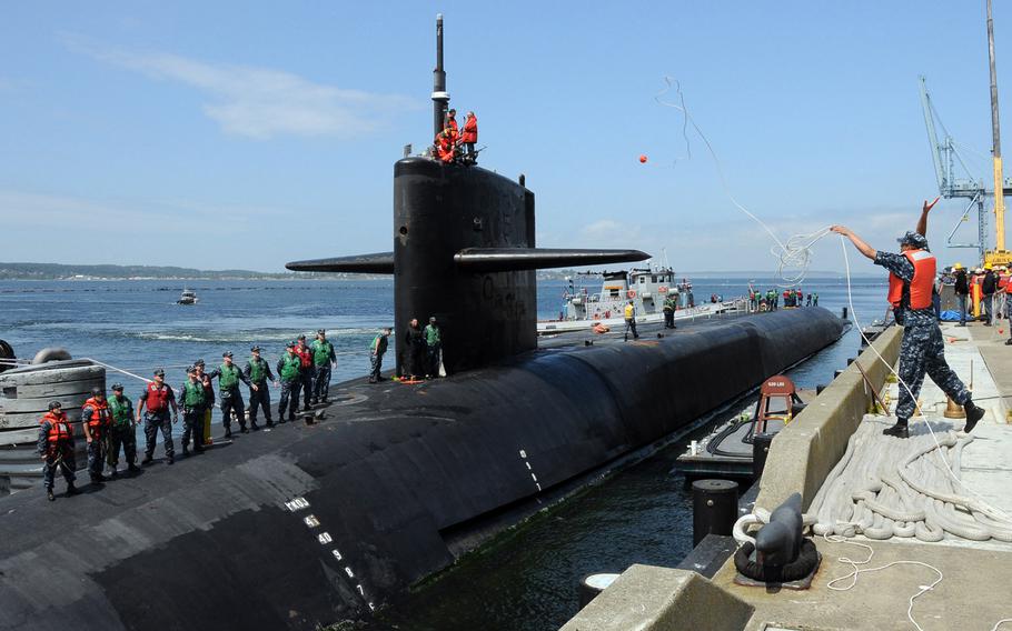 A sailor throws a heaving line to line handlers aboard the Ohio-class guided-missile submarine USS Michigan as it arrives at Naval Magazine Indian Island, June 8, 2011. The Navy announced Wednesday that it was opening billets onboard the Ohio-class sub to enlisted women, with plans of adding them to the boat in 2016.