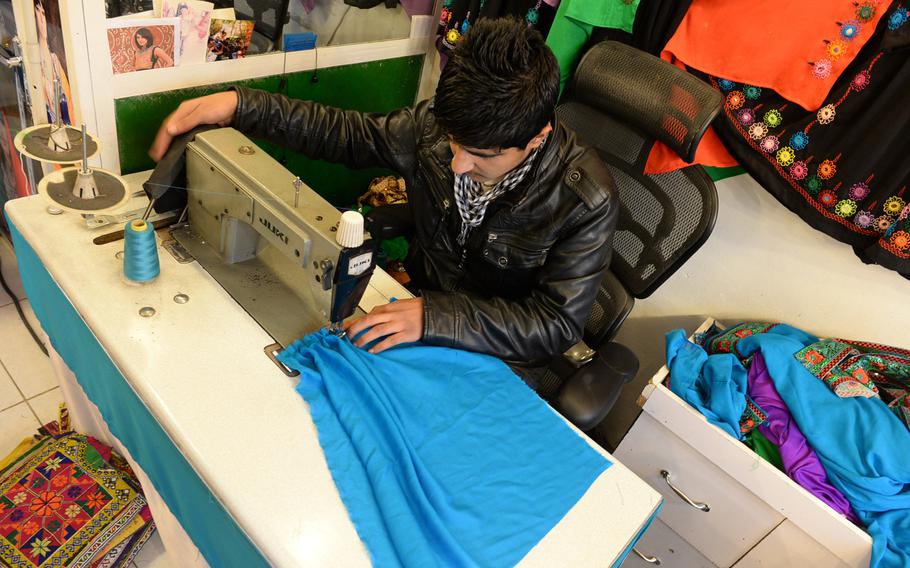 Rahim Amiri operates a sewing machine in his family's dress shop in Kabu, Afghanistan. The shop is one of many in Afghanistan that have seen business drop off as political controversy and ongoing violence lead to uncertainty.