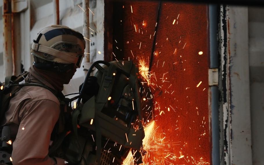 A U.S. Marine with the 15th Marine Expeditionary Unit's Maritime Raid Force practices breaching techniques during maritime interoperability training in San Diego Bay on Jan. 10, 2015.