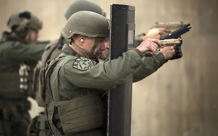 Lance Cpl. Christian Christopoulos engages targets behind a riot shield during weapons qualification Jan. 8, 2015, at Range 174 on Camp Hansen, Okinawa.