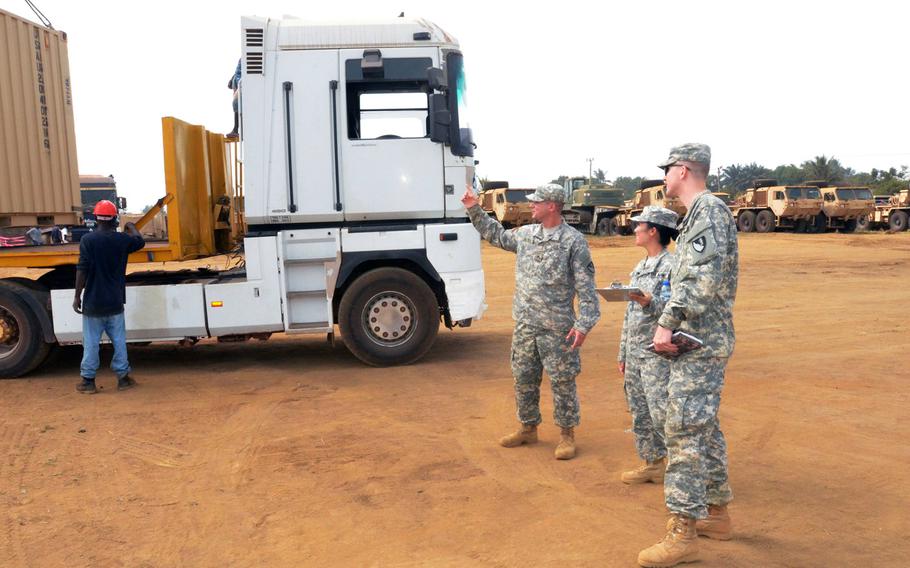 Cpl. James Lembke, left, a heavy equipment operator for the Headquarters and Headquarters Company, 62nd Engineer Battalion, 36th Engineer Brigade, briefs 1st Lt. Priscilla Ro, center, a unit movement officer, on the number of containers going on each of the non-tactical vehicles in support of Operation United Assistance, at the National Police Training Academy, Paynesville, Liberia, Jan. 15, 2015. Operation United Assistance is a Department of Defense operation in Liberia to provide support to U.S. Agency for International Development-led efforts to contain the Ebola virus outbreak in western Africa.