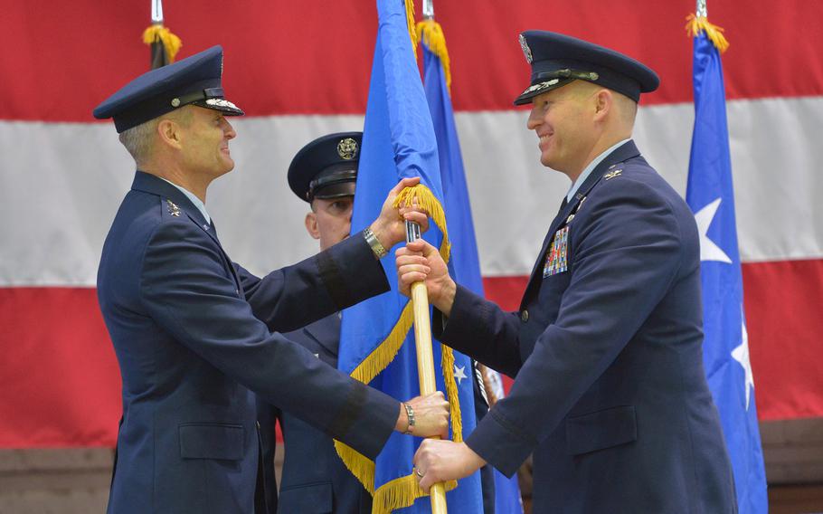 Col. Joseph McFall, right, takes the 52nd Fighter Wing colors from 3rd Air Force commander Lt. Gen. Darryl Roberson at McFall's assumption of command ceremony at Spangdahlem Air Base, Germany, Thursday, Feb. 5, 2015. At center is Command Chief Master Sgt. Brian Gates