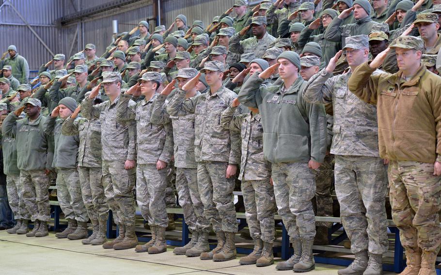 Spangdahlem airmen salute during the playing of the national anthem at the 52nd Fighter Wing assumption of command ceremony at Spangdahlem Air Base, Germany, Thursday, Feb. 5, 2015. Col. Joseph McFall took command of the wing at the ceremony.