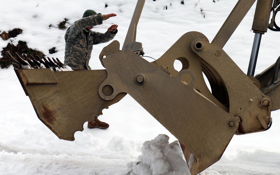 Spc. Isaac Viers, a heavy equipment operator assigned to the Virginia National Guard?s 276th Engineer Battalion directs a high-mobility engineer excavator to remove snow Feb. 28, 2015, throughout communities in Lee County, Va.