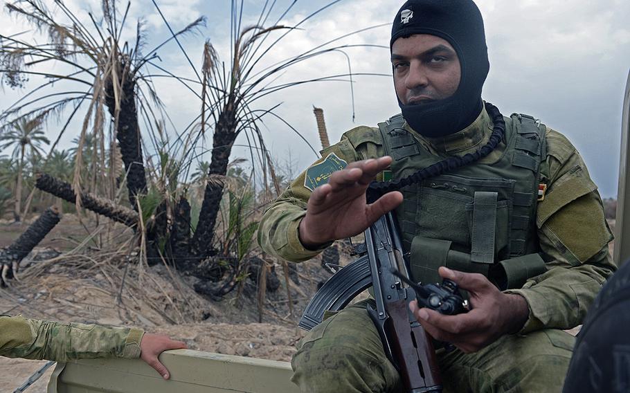A Badr Organization Shiite militiaman points out destroyed homes during a drive through Jurf al-Nasr, Iraq, March 8, 2015. Badr fighters joined other militias and the Iraqi army in an Iranian-backed assault that liberated the town in October, but Sunni residents have yet to be allowed back home.