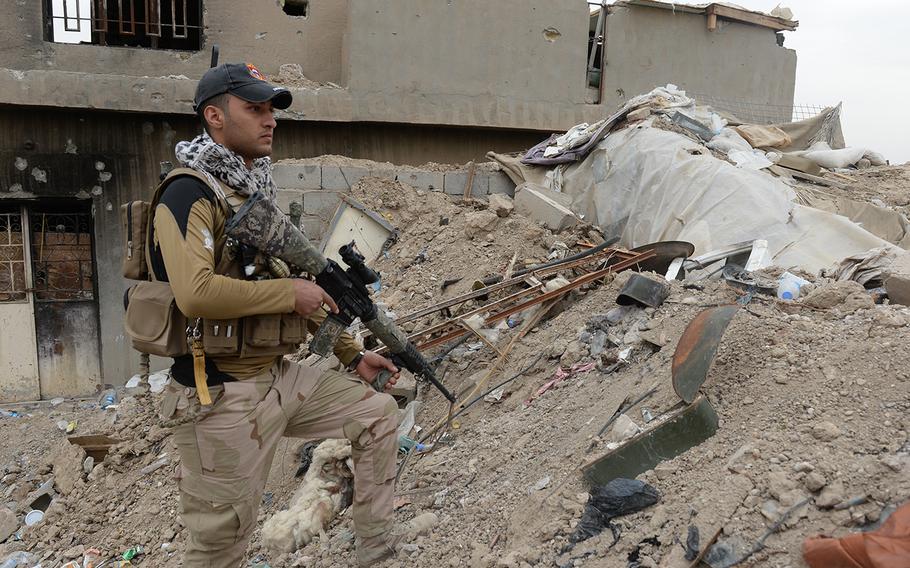 An Iraqi soldier surveys the front about 10 miles from the Islamic State stronghold of Fallujah, March 12 2015. He and fellow soldiers have been inching westward to stop rocket attacks against Baghdad.