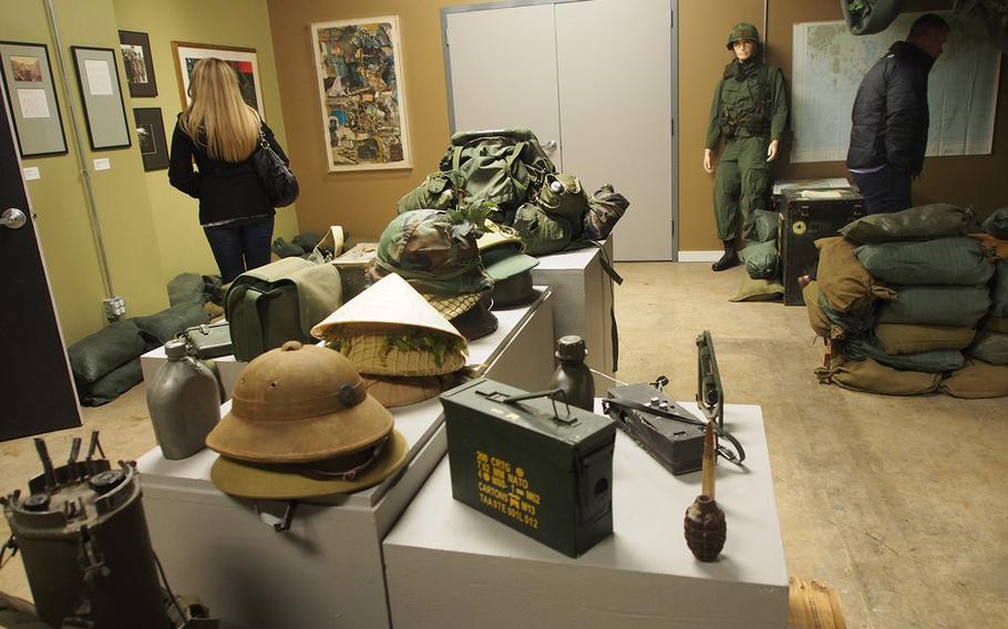 Visitors walk though "The Things They Carried" exhibit at the National Veterans Art Museum in Chicago. Part gallery and part hands-on exhibit, "The Things They Carried" is based on the book of the same name and offers visitors the chance to handle things like backpacks and grenades that troops carried with with them in Vietnam and see photographs and artwork made by troops in that conflict.