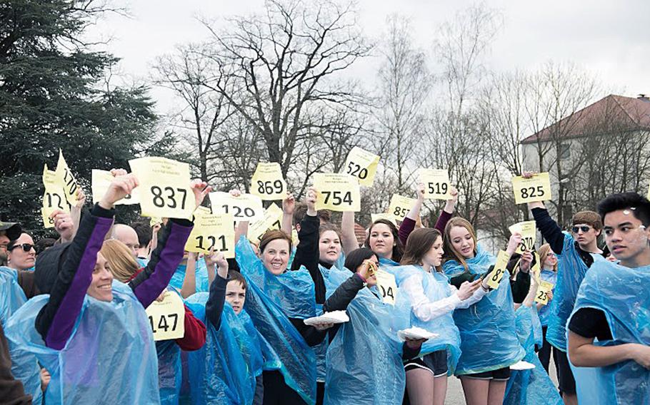 Patch High School students hold up numbers ahead of a massive shaving cream pie fight at Patch Barracks, Stuttgart, Germany March 12. The students threw 1,002 pies in an attempt to break the record of 815 set in 2013. Patch High now plans to submit its claim on the record to the Guiness World Records organization. Courtesy Virginia Kozak