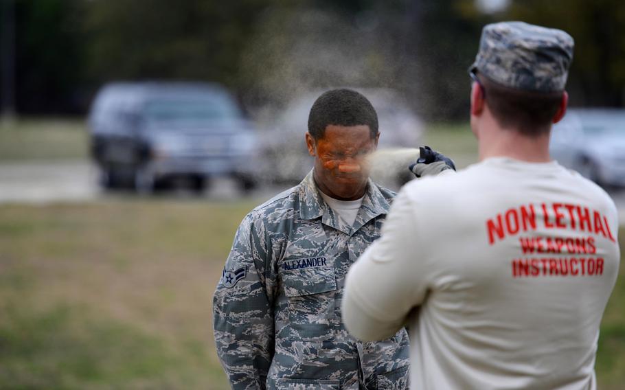 Airman 1st Class DeAaron Alexander receives a level-one contamination of oleoresin capsicum from Senior Airman Daniel Miller on Feb. 27, 2015, on Laughlin Air Force Base, Texas. After being hit with the pepper spray, the individual must then open their eyes, complete the five assessment stations and make it to the decontamination point on their own.