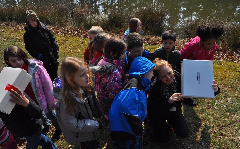 Ramstein Elementary School second-graders gather around their teacher, Yvonne Engels, to view an image of the partial solar eclipse through a handmade pinhole projector Friday morning, March 20, 2015, at Ramstein Air Base, Germany.