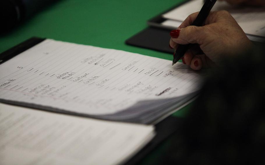 A judge writes out a spelle''s answer Saturday, March 21, 2015, at the European PTA Spelling Bee at Ramstein Elementary School in Germany.
