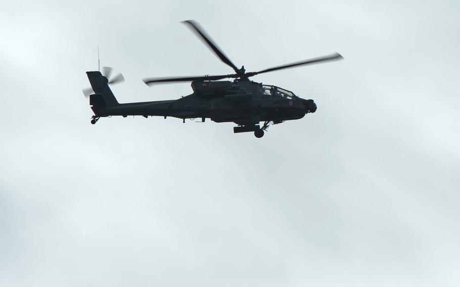 An AH-64 Apache helicopter escorts Strykers of Lightning Troop, 3rd Squadron, 2nd Cavalry Regiment as they convoy from Alytus, Lithuania, to the Polish border, Monday, March 23, 2015.