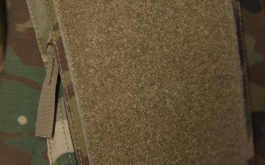 The hook and loop closure has been removed from the upper sleeve pocket in favor of a zipper.