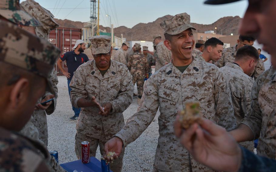 Marine Master Gunnery Sgt. Celestino Vargas takes a handful of food during a banquet thrown by Jordanian forces at Camp Titin, Jordan, on May 16, 2015. The event celebrated the end of the annual exercise Eager Lion.