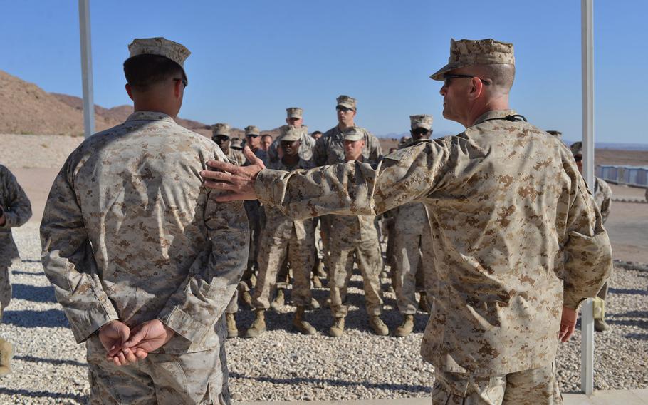 Marine Maj. Gen. Burke Whitman, right, speaks before presenting Sgt. Curtis Pannier with a bachelor's degree on May 15, 2015, at Camp Titin, Jordan. Pannier, a logistics chief, completed a program in logistics over several years through online courses with American Military University. Pannier and other Marines were in Jordan for the annual exercise Eager Lion.