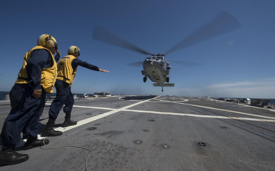 U.S. Navy Boatswain's Mate 2nd Class Bethany Paquet helps guide an MH-60S Seahawk onto the flight deck of the guided missile destroyer USS Oscar Austin in the Baltic Sea June 12, 2014, during Baltic Operations 2014. BALTOPS is an exercise designed to enhance multinational maritime capabilities and interoperability between the U.S. and European nations in the Baltic region.