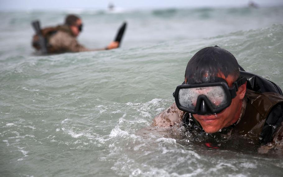 Marines with 1st Marines Special Operations Support Battalion don fins before swimming through the surf zone during the Tactical Skills Package aboard Marine Corps Base Camp Pendleton, Calif., May 14, 2015.