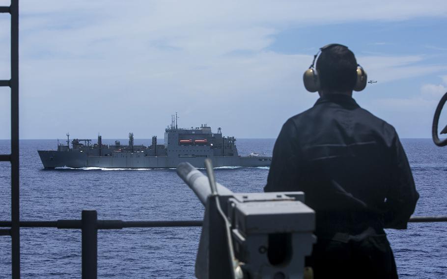A U.S. sailor with the USS Essex Amphibious Ready Group watches the USNS Wally Schirra during a replenishment at sea aboard the USS Essex in the Pacific Ocean, on May 31, 2015.