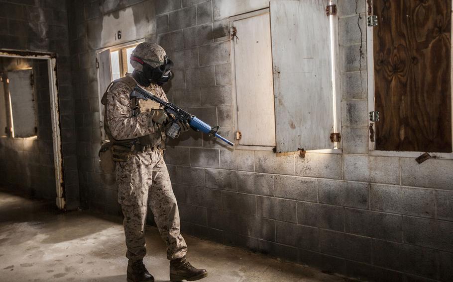 U.S. Marine Corps 1st Lt. Ian A. Killough, an infantry officer with 1st Battalion, 8th Marine Regiment, 2nd Marine Division, looks out of a window while conducting urban operations during Professional Training for Midshipmen on Camp Lejeune, N.C., June 3, 2015.
