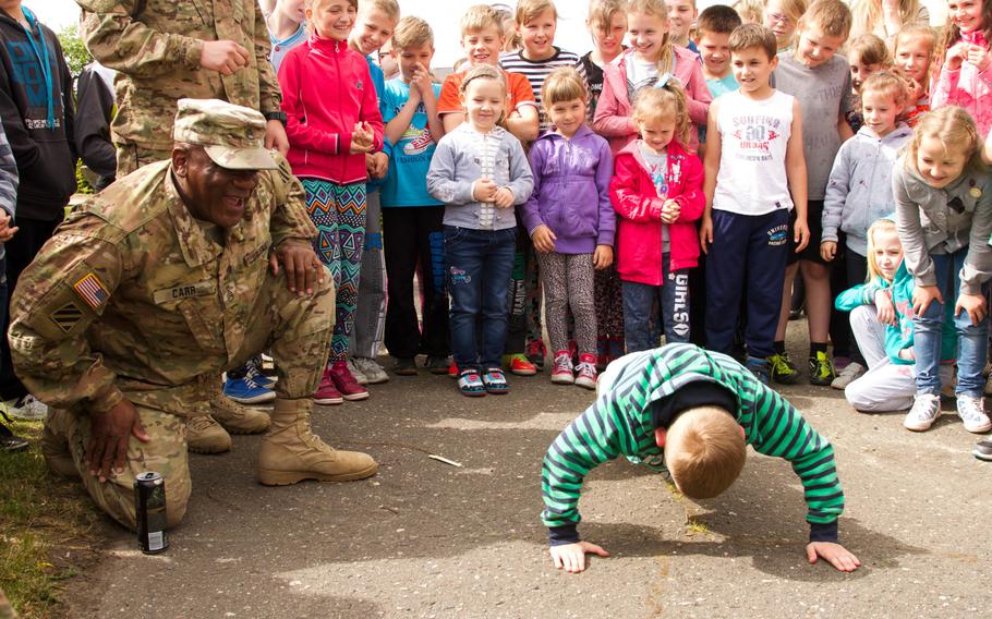 Staff Sgt. Marcus Carr Sr., with the 3rd Infantry Division, referees a push-up competition with students from the 2nd Brigade Artillery School on May 29, 2015, in Drawsko Pomorskie, Poland.