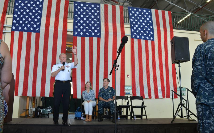 Army Gen. Martin Dempsey, chairman of the Joint Chiefs of Staff, speaks before an audience of sailors at the Navy base in Naples, Italy, on June 11, 2015, as Adm. Mark Ferguson, commander of U.S. Naval Forces Europe-Africa, and Dempsey's wife, Deanie Dempsey, watch from the stage.