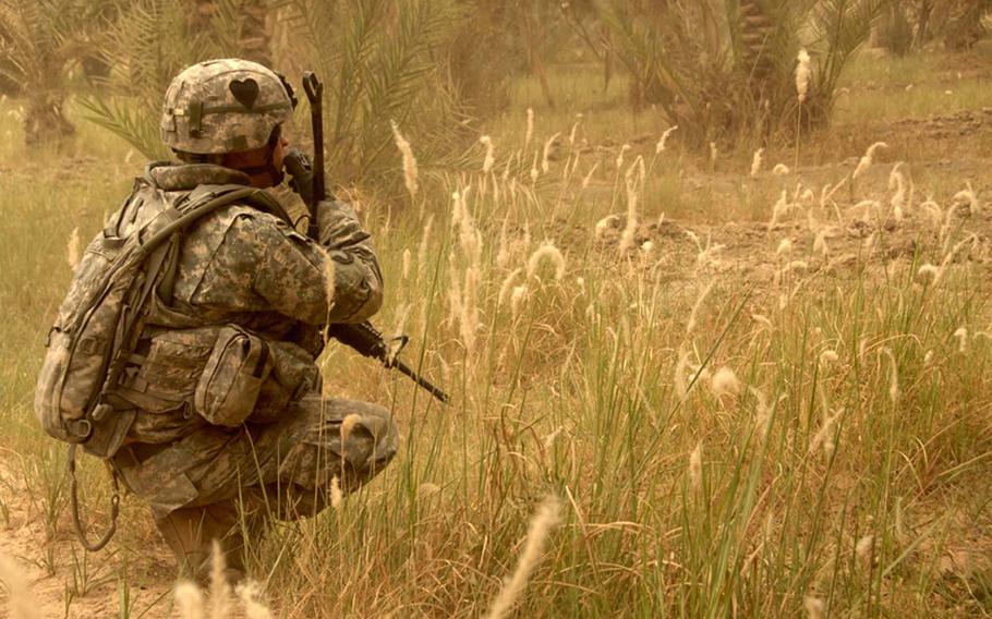 In this image taken by 55th Combat Camera, a U.S. Army soldier radios to his fellow soldiers while searching for weapons caches in northwest Shulla, Iraq, May 16, 2008. Three combat camera troops have been killed while covering the troops fighting in Iraq and Afghanistan.
                