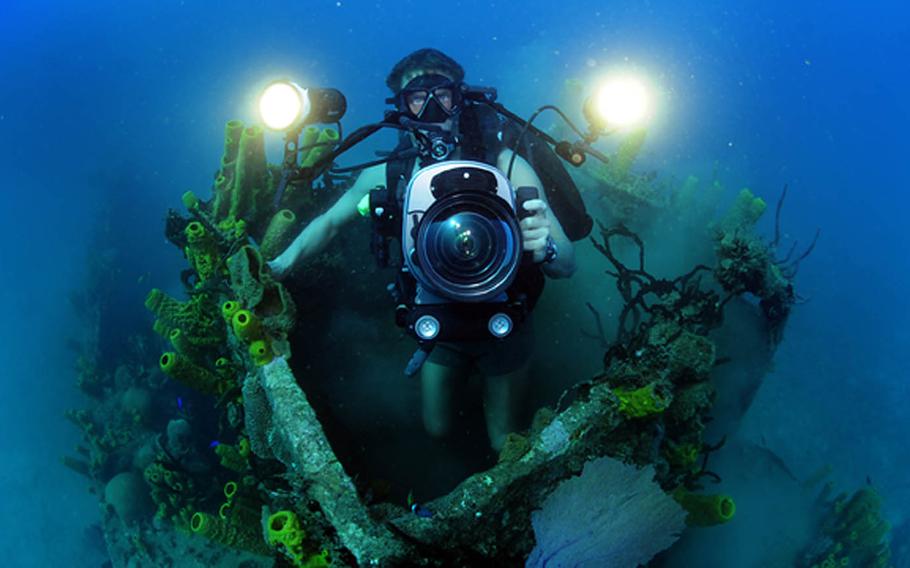 Mass Communication Specialist 1st Class Shane Tuck films coral growth in the pilot house of a sunken naval landing craft off the coast of Guantanamo Bay, Cuba, Feb. 9, 2012. Expeditionary Combat Camera's Underwater Photo Team conducts semi-annual training to hone its divers' specialized skill set and ensure valuable support of Department of Defense activities worldwide.
                
