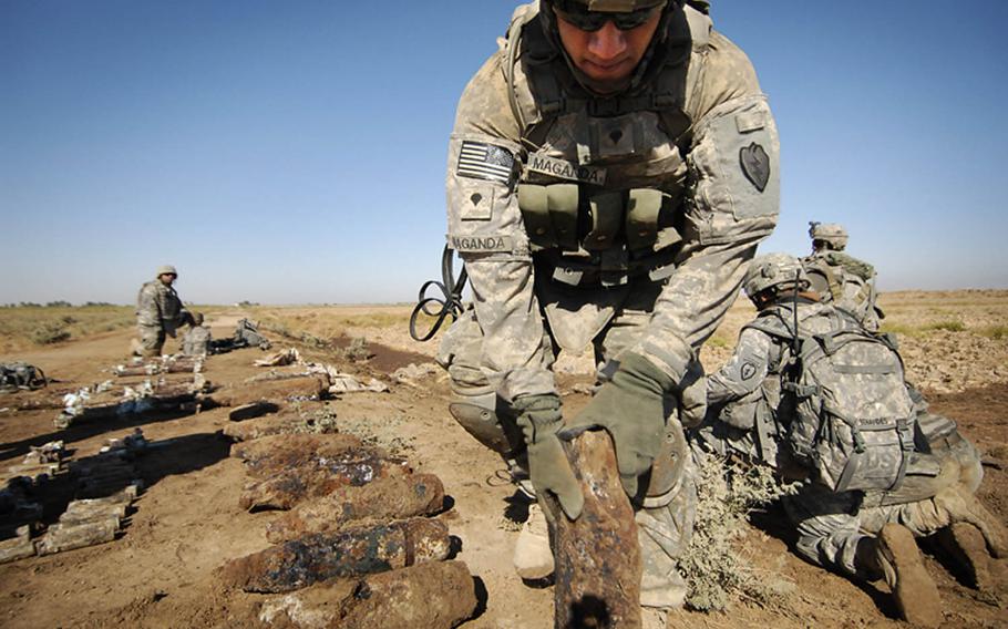 In this combat camera image, U.S. Army Spc. Jose Maganda, Company C, 1st Battalion, 27th Infantry Regiment, lays out mortar rounds his unit just discovered, Oct. 4, 2008. Soldiers from 2nd Stryker Brigade Combat Team, 25th Infantry Division, conducted a cache search in the rural region of Zoba, Iraq. Combat camera troops learn combat skills and small unit tactics to allow them to integrate with ground combat forces.
                