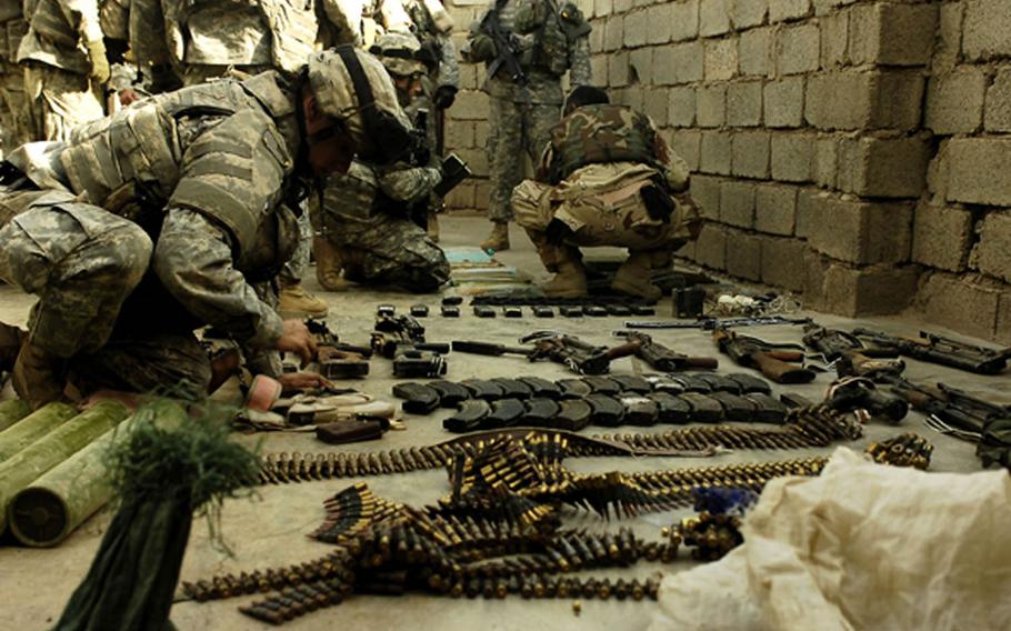 A coalition soldier and Iraqi army soldier count materials found in a large weapons cache in 2006 in Hawija, Iraq, in this combat camera photo. The 700 active-duty troops assigned to combat camera learn combat skills and small unit tactics to allow them to integrate with ground combat forces.
                