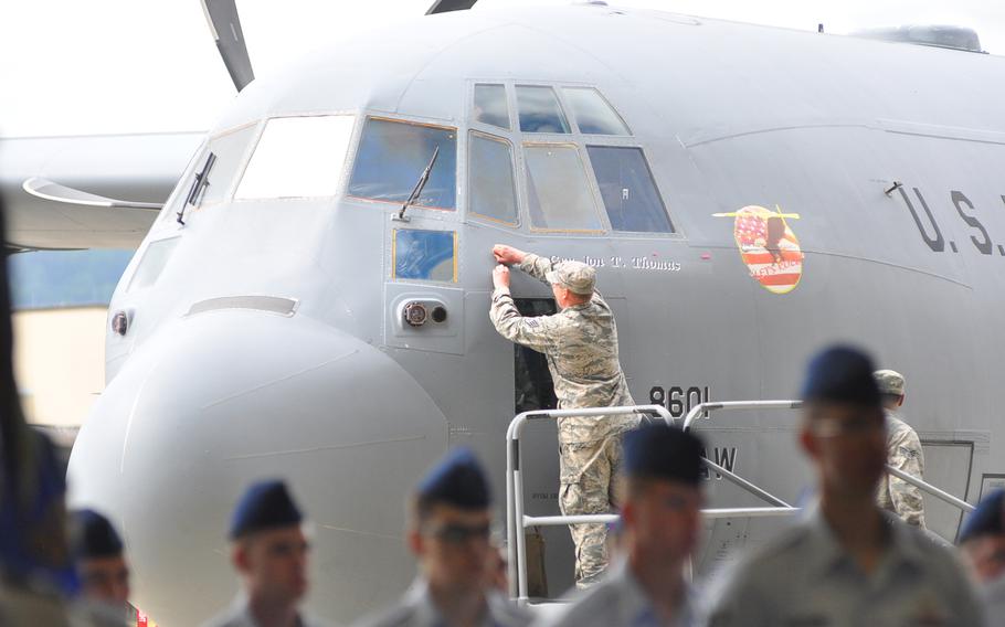An airman makes an adjustment to a spot on a C-130 next to the name Brig. Gen. Jon T. "Ty" Thomas, the new commander of the 86th Airlift Wing at Ramstein Air Base, on June 19, 2015. Per tradition, Thomas' name was unveiled on the plane during Friday's change-of-command ceremony.