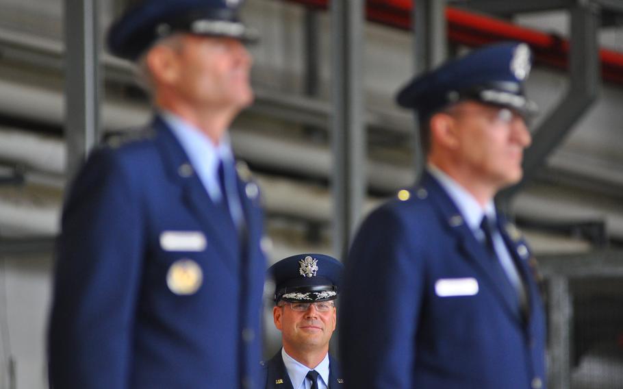 Brig. Gen. Jon T. "Ty" Thomas, the new commander of the 86th Airlift Wing, stands in the background behind Lt. Gen. Darryl L. Roberson, left, 3rd Air Force commander, and Brig. Gen. Patrick X. Mordente, the wing's outgoing commander. Thomas took over the job from Mordente at a change-of-command ceremony on June 19, at Ramstein Air Base, Germany.