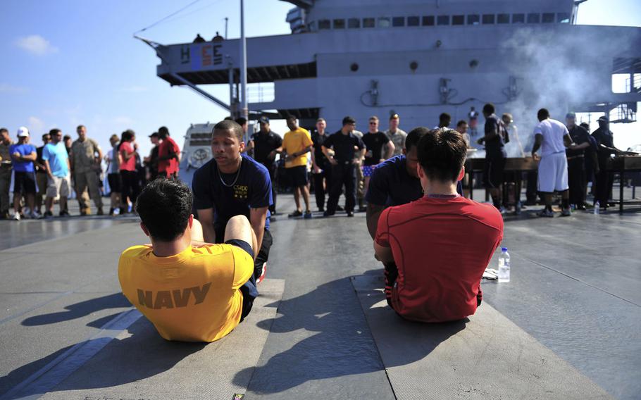Seaman Sebastian Rivasseau, bottom left, and Fireman Jinsuk Lee, bottom right, compete in a sit-up competition on the USS Blue Ridge on May 10, 2015. The Navy is considering retooling its fitness program after more than 5,000 sailors failed their annual fitness test last year.