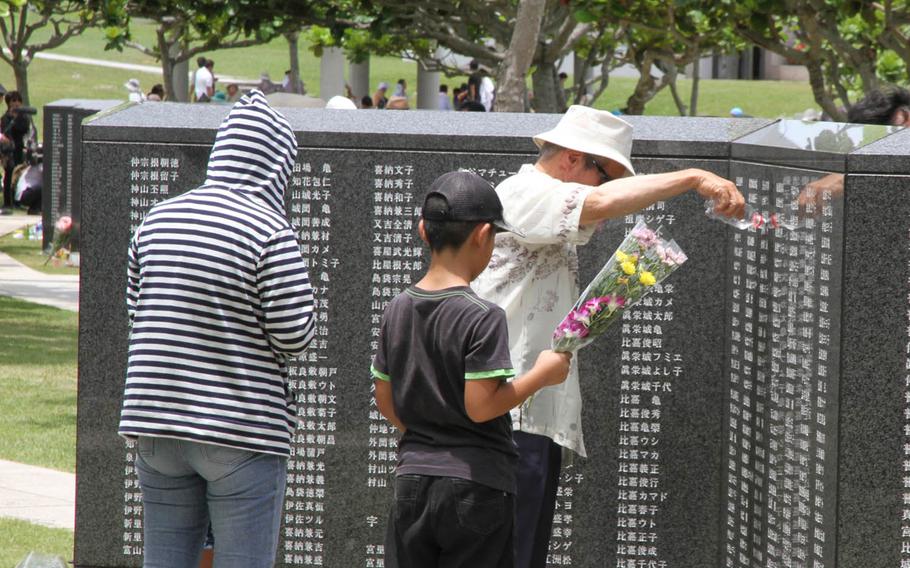 A man offers an ancestor a drink of water during the annual Irei no Hi ceremony commemorating the Battle of Okinawa, which gives locals a chance to connect with lost family and friends. Approximately 100,000 locals perished in the battle. 