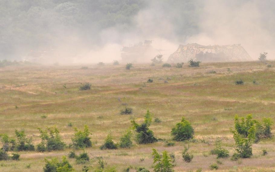 Moments after beginning to fire their guns, two U.S. Army M1A2 Abrams tanks are enveloped by smoke at a live-fire exercise that closed the Kabile 2015 tactical exercise at Novo Selo Training Area, Bulgaria, on Thursday June 25, 2015. About 50 U.S. Army troops from 3rd Combined Arms Battalion, 69th Armor Regiment and 2nd Squadron, 2nd Cavalry Regiment took part in the demonstration.