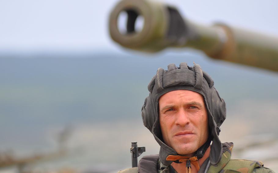 A Bulgarian tanker stands outside his vehicle following a live-fire exercise that closed the Kabile 2015 tactical exercise at Novo Selo Training Area, Bulgaria, on Thursday June 25, 2015.
