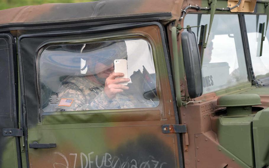 A solider makes a video as he and other members of 5th Battalion, 7th Air Defense Artillery Regiment, cross the Weser River over a temporary bridge built by British and German engineers near Petershagen, Germany, Tuesday, July 28, 2015.