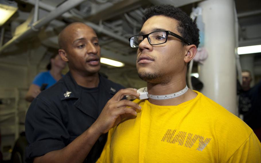 Petty Officer 1st Class Webster Bailey, left, measures the neck of Seaman Jordan Bransfield during a body composition assessment April 23, 2014, aboard the guided missile destroyer USS Arleigh Burke in the Persian Gulf. Changes to the Navy's physical fitness assessment to be introduced in 2016 will lower the emphasis on body weight in favor of more sailors taking the exercise portion of the test.